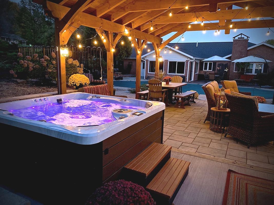 Backyard hot tub under a pergola at dusk