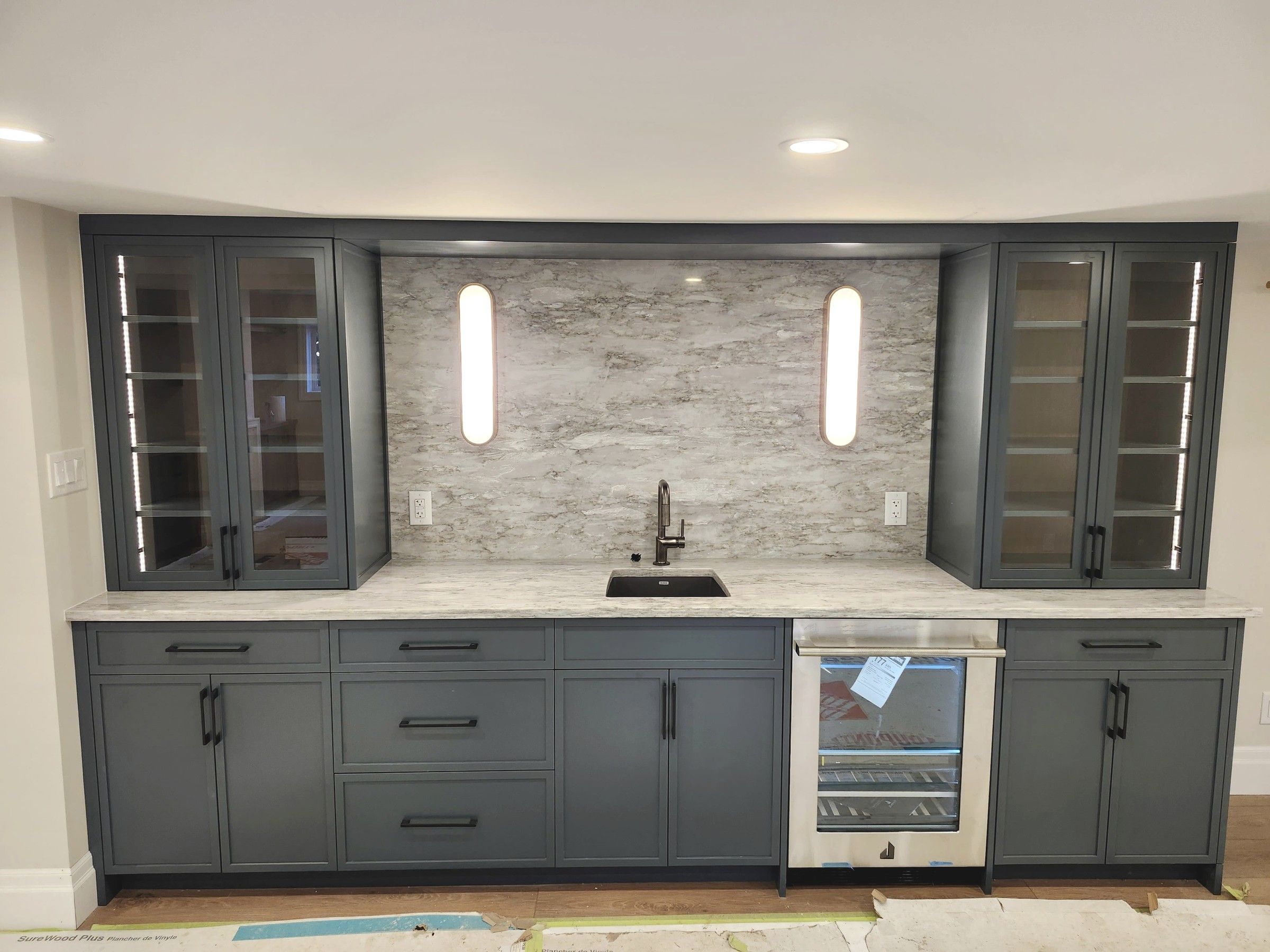 Basement wet bar with wall sconces and cabinet lighting