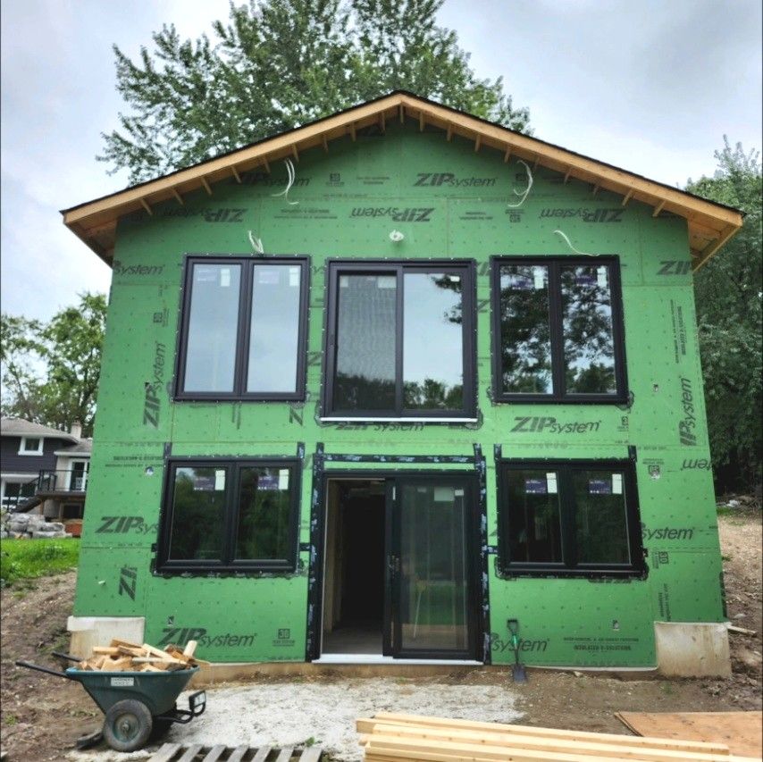 Two-storey new home in green ZIP System sheathing with black windows