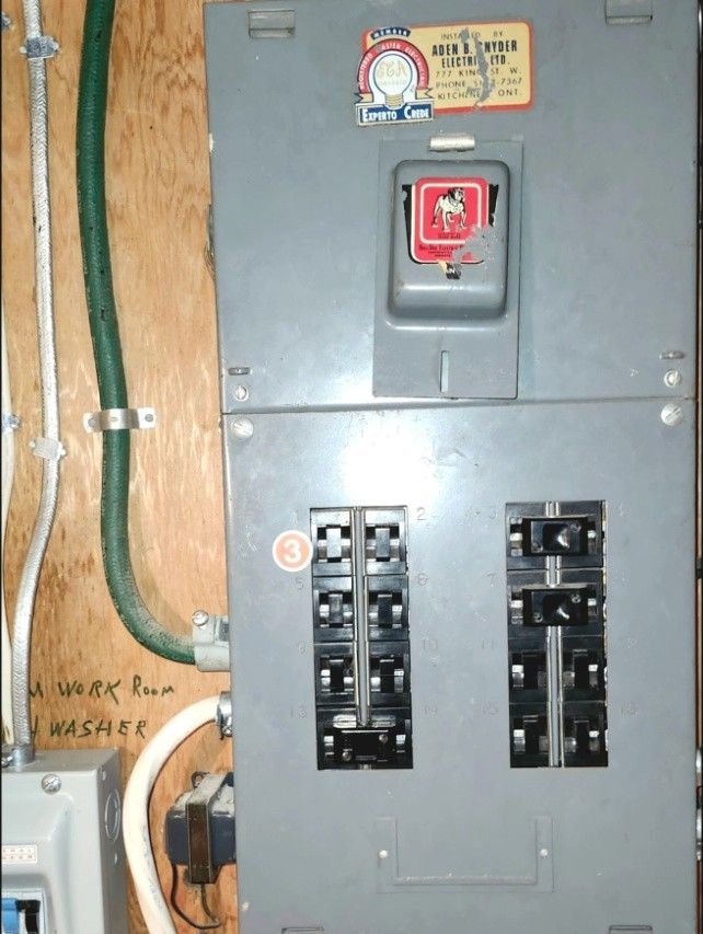 Old fuse panel and switch on a plywood backboard before an upgrade